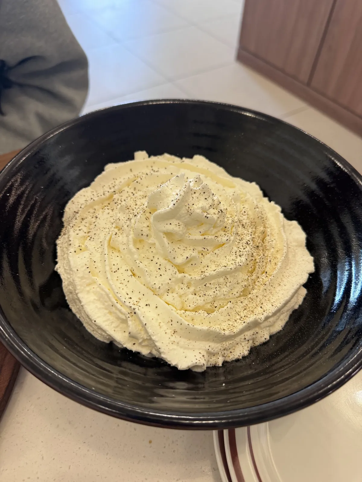 Bowl of whipped cream with black pepper